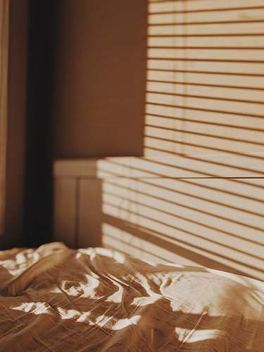 furniture photo of beige bed sheet and white bed headboard bedroom